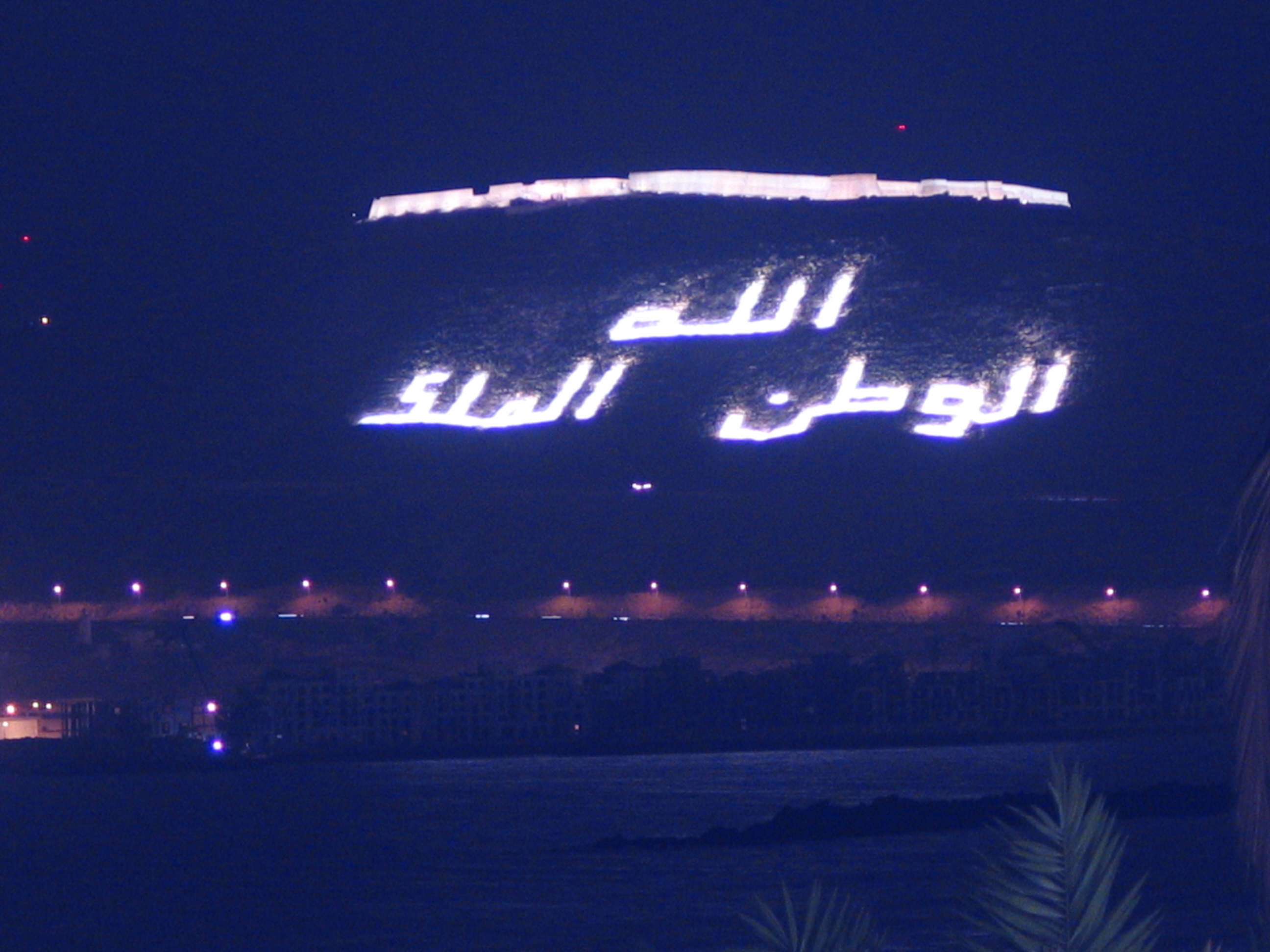 The Kasbah hill of Agadir Oufella at night with the illuminated inscription God, the Homeland, the King