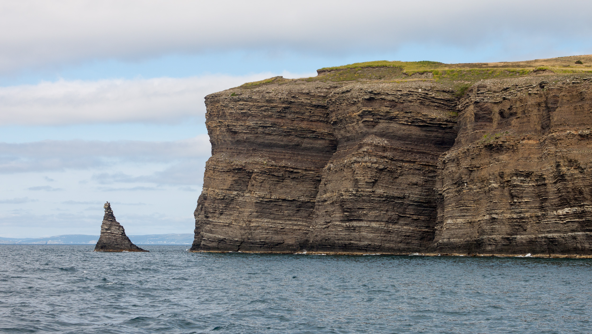 The coastal cliffs of Bell Island, Newfoundland, rising from Conception Bay