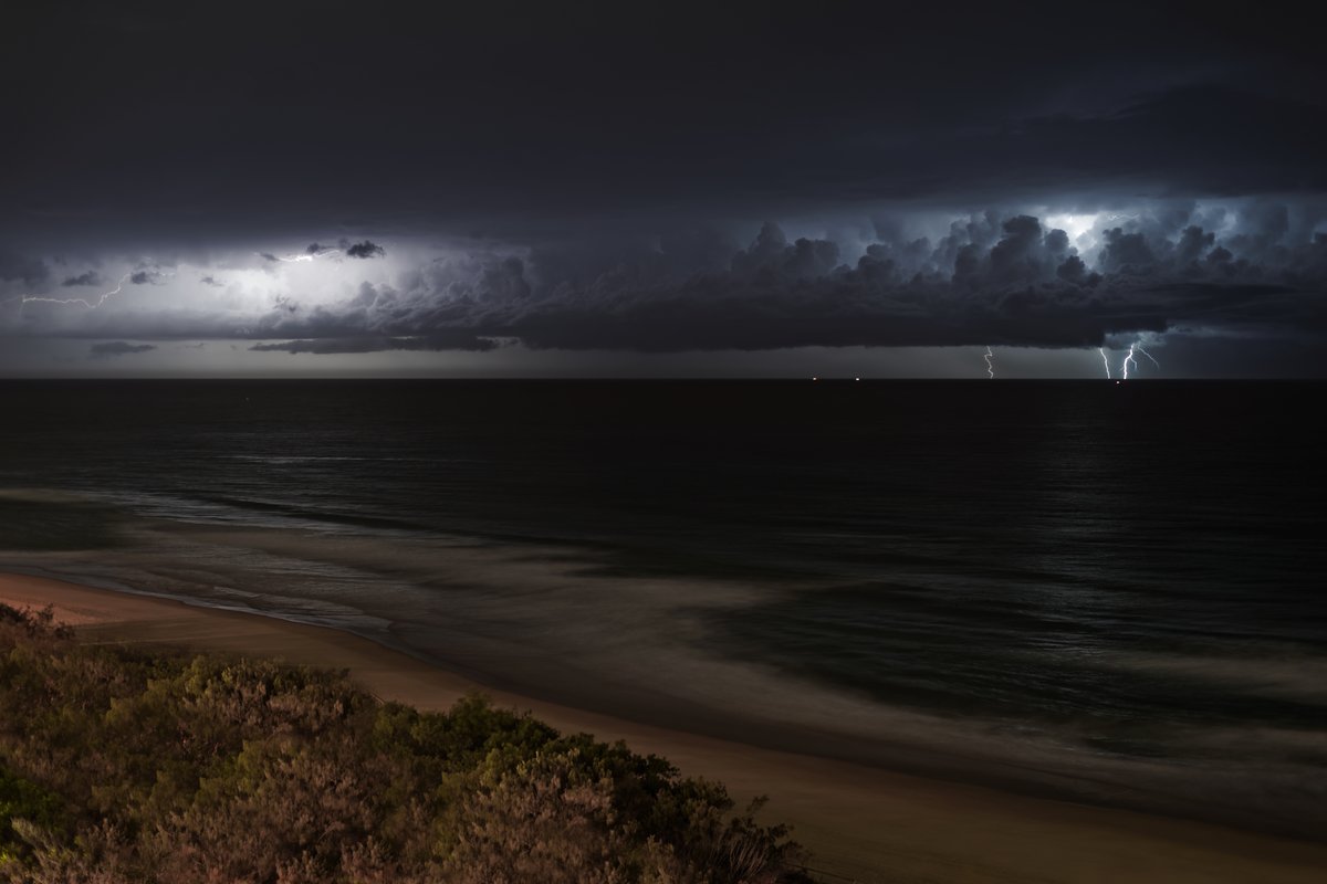A powerful lightning strike over the ocean at night