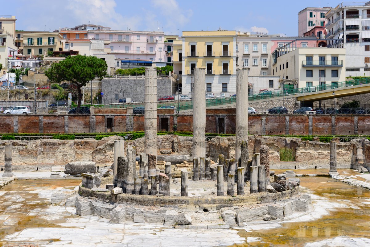 The three surviving marble columns of the Macellum of Pozzuoli, with a dark band of mussel borings partway up