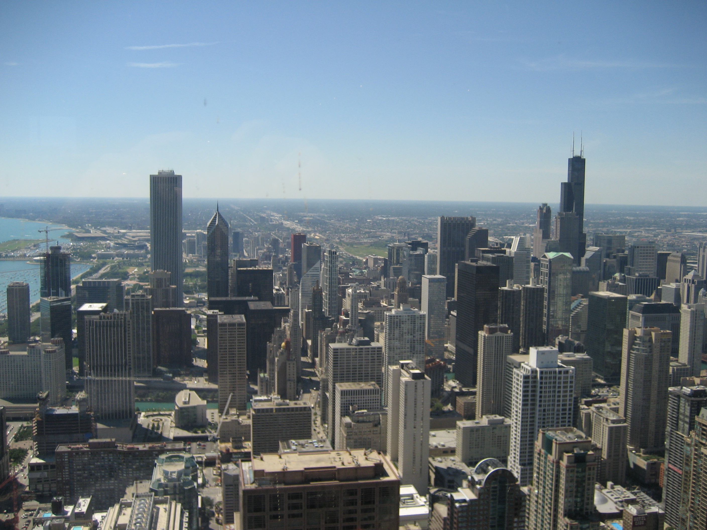 Chicago skyline viewed from above, showing the Sears Tower and John Hancock Center with their broadcast antennas