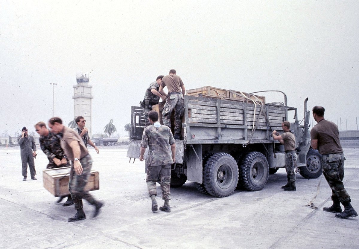 Personnel and a helicopter amid ash-covered facilities at Clark Air Base during the 1991 eruption